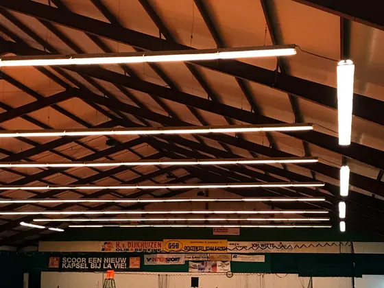 Overdekte tennishal verlicht met lange rijen ledarmaturen